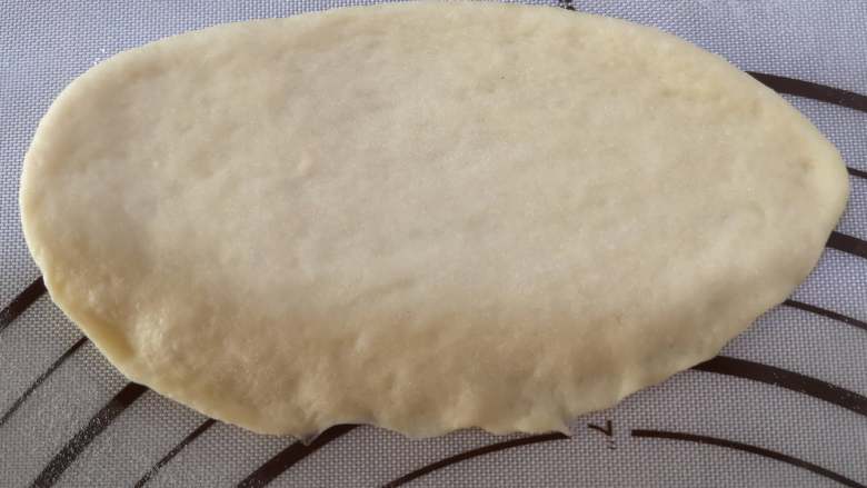 绵软美味的淡奶油花包,取出一个小面团，擀成长一些的椭圆形，将底部的面皮压薄。