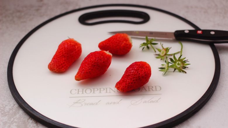 番茄草莓蜂蜜汁,用刀先把<a style='color:red;display:inline-block;' href='/shicai/ 592'>草莓</a>的根蒂切出。