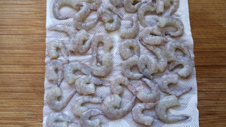 西兰花炒虾仁,用厨房纸吸虾仁干表面水份。