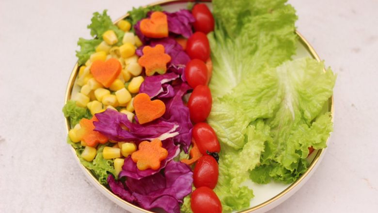 鸡胸肉时蔬沙拉,取一个大一点的盘子，盘子底下先铺上洗净的蔬菜，分别把玉米粒和紫甘蓝，胡萝卜和番茄摆盘。
