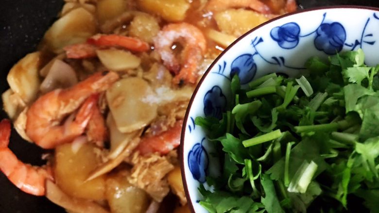 大虾土豆腐竹杏鲍菇年糕锅,加入香菜，翻炒均匀即可