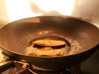 鸡胸肉三明治,锅中放入少量的油，一面煎熟后翻面煎另一面。如果是早晨做三明治，鸡胸肉可以提前腌制好放入冰箱，第二天早上直接煎。