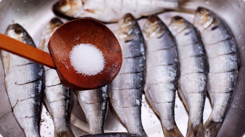 干炸海鲫鱼,依次把所有的海鲫鱼都改好刀，再根据个人口味加入适量的盐调味。