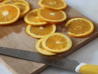 满满“一颗橙子”的香橙蛋糕卷,1. 【糖煮橙皮】
橙子先用盐搓洗后用水冲干净（除了杀菌，清除部分蜡质表层外更能激发橙子的香气）。擦干表皮后尽可能切成薄片（两端不要）。表白关东刀，真的很好用！！

