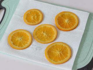 满满“一颗橙子”的香橙蛋糕卷,5. 取5片制作好的橙片，用厨房纸吸干多余水分。这一步很重要！！过多的水分会泡稀周围面糊，导致橙片不服贴以及部分蛋糕卷组织不佳
