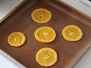 满满“一颗橙子”的香橙蛋糕卷,15. 烤盘中铺好油布，然后摆上5片橙片，不要摆的太靠边缘，会影响卷卷

