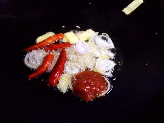 烧鲫鱼,油锅烧热，放入毛葱、生姜、干辣椒爆香，放入番茄沙司炒匀