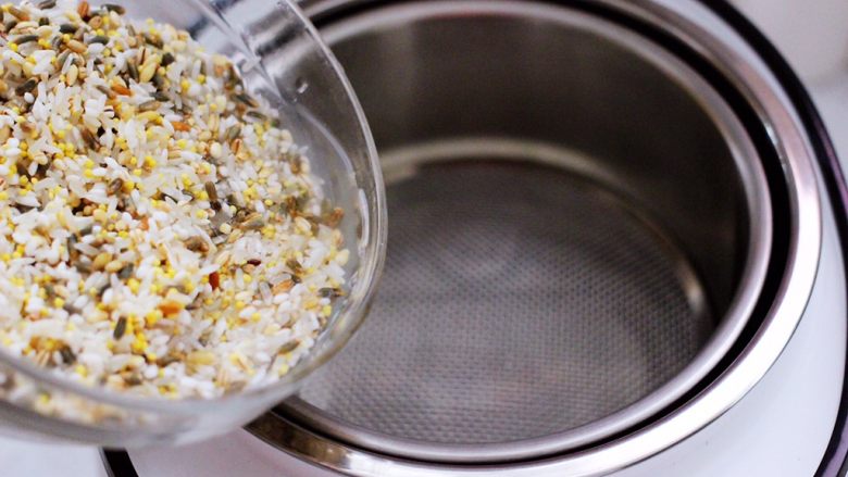 麦仁青稞杂粮饭,把清洗干净的杂粮放入电饭煲里。