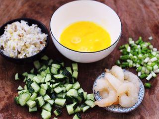 黄瓜虾仁杂粮蛋炒饭,把黄瓜洗净后，用刀切成小丁，小葱切碎，鸡蛋打散备用。