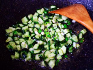 黄瓜虾仁杂粮蛋炒饭,锅中的底油，先爆香小葱后再放入黄瓜丁继续翻炒片刻。
