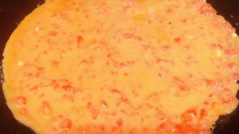 西红柿蛋饼,锅中倒入底油加热倒入适量西红柿鸡蛋面糊中小火煎起来