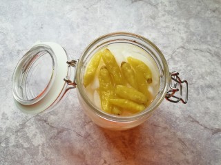 泡椒萝卜条,将调好的泡椒糖醋水倒入密封罐，没过萝卜条，放入泡椒，盖上密封罐的盖子。