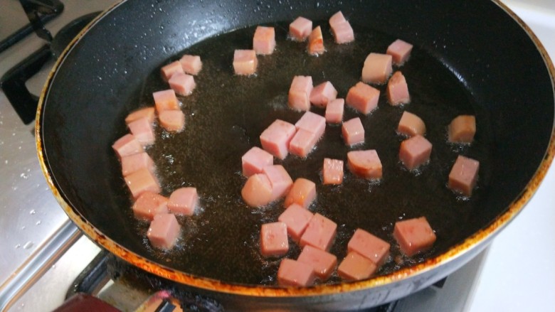 紫薯馒头抱蛋,平底锅倒入适量油，炒午餐肉块。