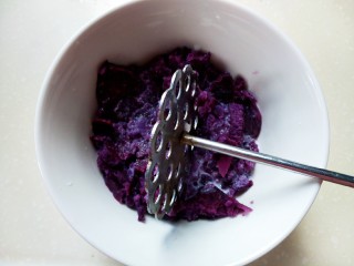 紫薯肉松三明治,蒸熟的紫薯放入碗中，加入适量的炼乳跟牛奶，把紫薯压成泥状。