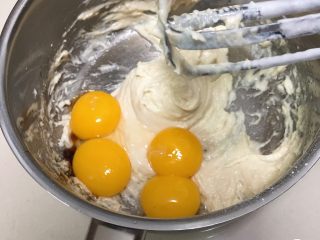 葡萄干蛋糕,加入蛋黄和香草精，打蛋器低速搅拌均匀。