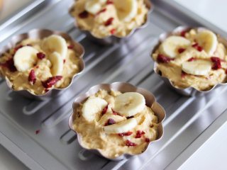 香蕉蔓越莓玛芬蛋糕,顶部撒上剩余的蔓越莓干和香蕉片。