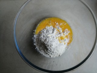 鸡蛋烤饼,先做第1个面团，面粉平均分成两份，每份75克。把酵母溶于水里，27克蛋液倒入其中一份75克面粉里