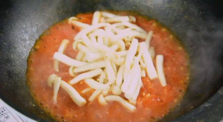 番茄与海鲜菇能碰撞出怎样的火花?美味是必然的,营养更是丰富,倒入番茄丁，炒软，加入清水、海鲜菇，炒匀
