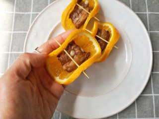 香橙排骨,将蒸熟的排骨取出放在香橙片上包裹一下，用牙签固定好。