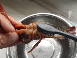 佛系龙虾粥,泡上大米后，来处理小龙虾，用牙刷将小龙虾刷干净，去虾线。
将头和身子分开，取头部的虾黄（头里还有一部分，抠一下，是黑色的就不要了）。