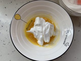 奶香手指饼,取三分之一的蛋白霜，加入蛋黄糊拌匀