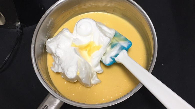 椰蓉蛋糕,用刮刀翻拌均匀后取三分之一的蛋白进蛋黄糊中。