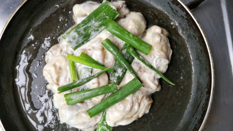 金牌海蛎煎,摊平，煎一会，放入葱段。