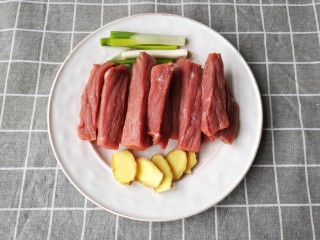 牛肉干,将牛肉顺丝切成厚度约2指的长条，葱切段，姜切片。