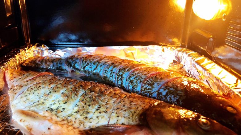 烤箱版烤鱼,5.烤盘上铺上锡纸，放入腌好的鱼，刷一层油，入烤箱上下火220度，烤30分钟左右（锡纸哑光面接触到鱼）