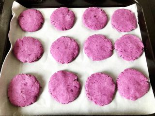 紫薯饼,10.烤盘上垫上油纸，把紫薯分成30g左右的小球，把紫薯小球压扁，整齐的摆放在烤盘中