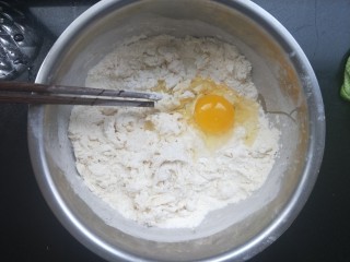 香煎花卷,酵母水倒进去，再打一个鸡蛋进去，再另外加水，一边加水一边搅拌，拌成棉絮状