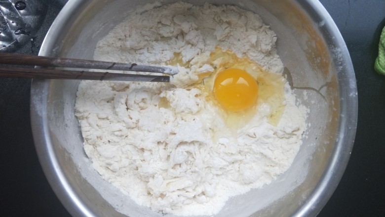 香煎花卷,酵母水倒进去，再打一个鸡蛋进去，再另外加水，一边加水一边搅拌，拌成棉絮状