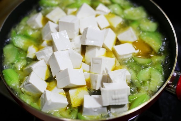 鲜掉眉毛的丝瓜豆腐汤,把沥干水的豆腐捞出放入锅中。