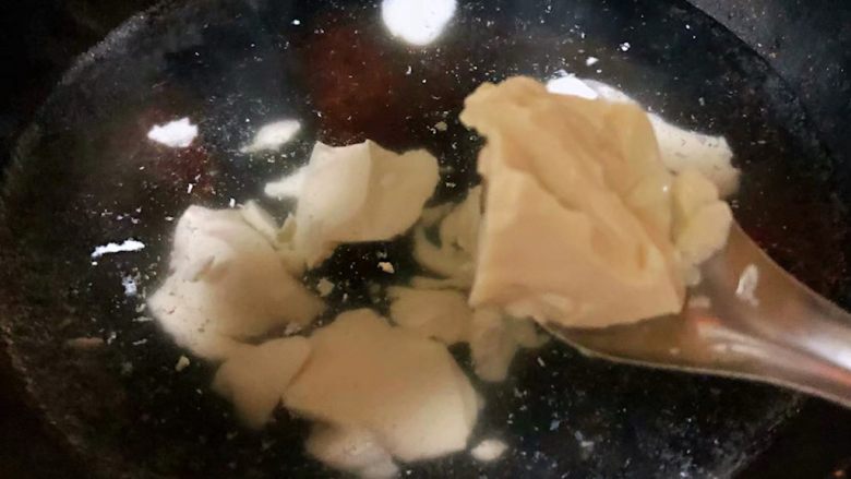 秋葵香肠豆腐羹,锅中倒入适量清水用勺子舀内脂豆腐放入水中