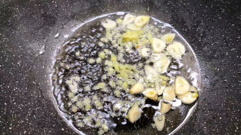 虾仁炒芦笋,热锅放入适量油，放入姜末和蒜片炒出香味。