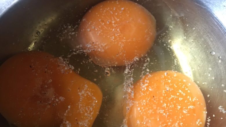 豆角猪肉炒鸡蛋,鸡蛋打开加入适量油盐胡椒粉，然后打匀。