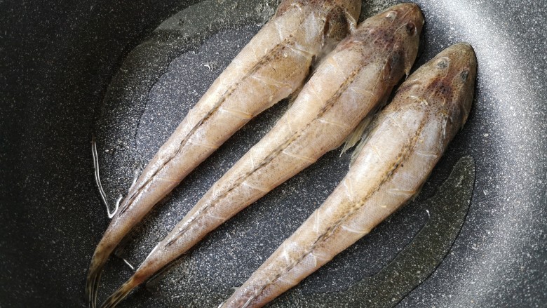 亚麻籽粉饽饽煎鱼,平底煎锅中加入适量的油，烧热后把腌制好的鱼入锅。