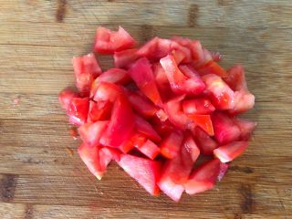 茄汁金针菇肥牛,西红柿清洗干净，用刀在西红柿表面划上十字花刀，用开水烫1分钟，再剥掉西红柿的外皮，再切成小块待用。