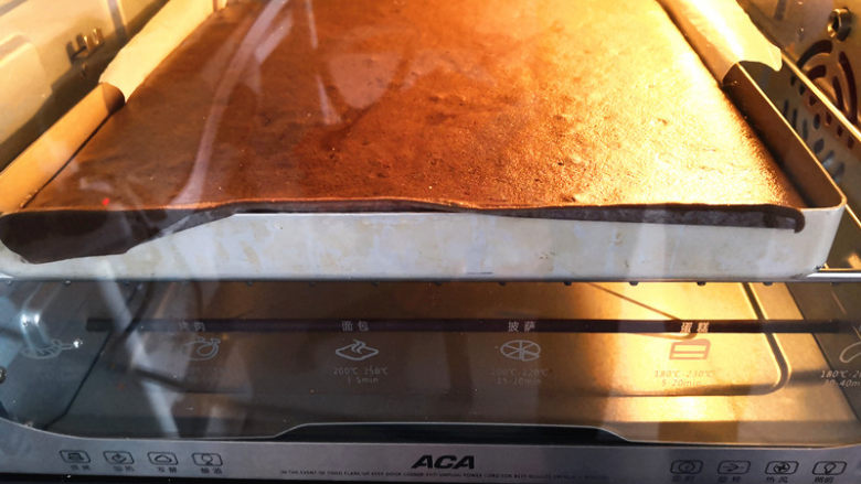 可可蛋糕卷,烤箱预热，上下火，中下层，170度烤20分钟左右，烤好的蛋糕体提着油纸取出来，小心地撕去四周的油纸放在烤网上晾凉，

