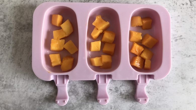 芒果酸奶雪糕,模具中放入适量的芒果丁