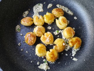 多味小土豆,待小土豆两面都煎至金黄后下蒜末，翻炒出香味。