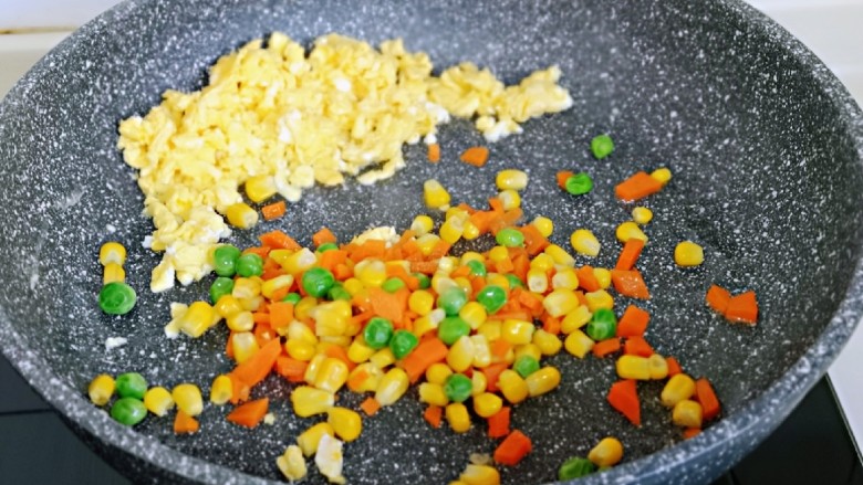 小熊便当套餐,把鸡蛋碎放在锅旁边，加入焯水的彩蔬翻炒均匀。