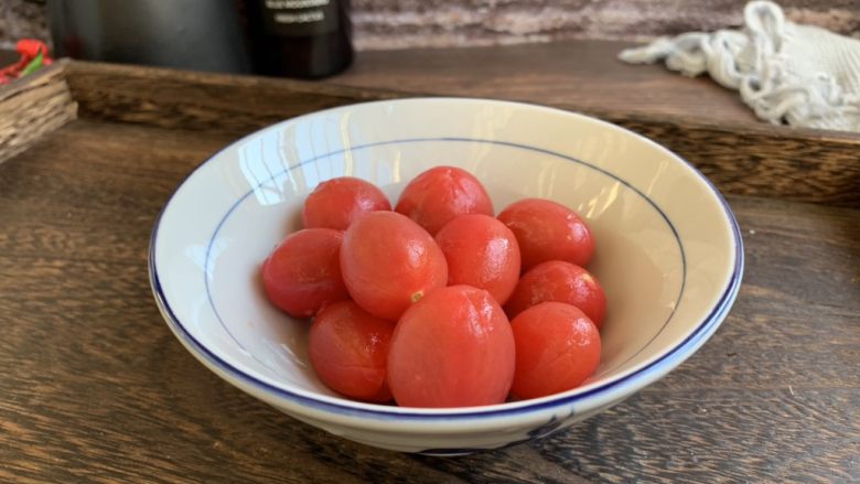 陈皮小番茄,将每粒小番茄的皮剥下去。