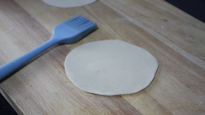 香酥鸡柳卷饼,取两个面团压扁，用擀面杖擀大一些，在一个面团表面刷上薄薄的一层油。
