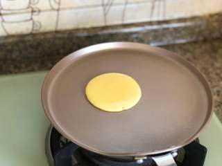 铜锣烧,小火预热平底锅。 一定要用不粘锅，好的锅受热均匀，煎出来的铜锣烧颜色也会非常的好看。 手放在平底锅的上方，可以感觉得到温度，就可以了。 把面糊放到平底锅里。