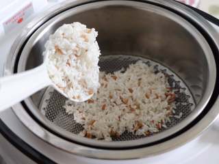 紫薯麦粒米饭,把甑子放到锅里，放好小滤网之后，把大米麦粒放到小滤网上，铺平。