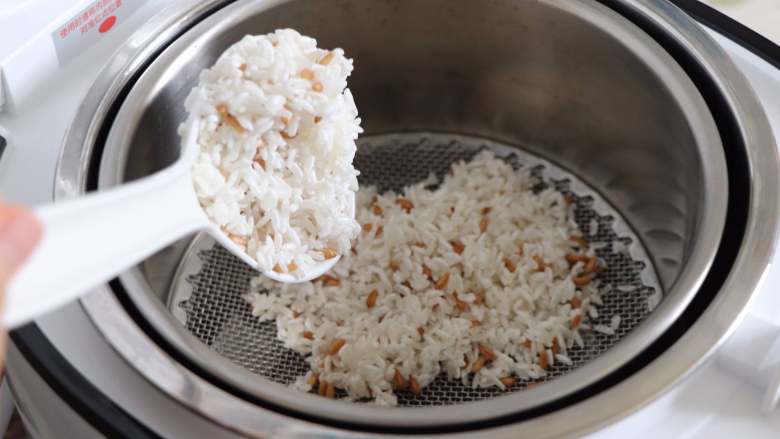 紫薯麦粒米饭,把甑子放到锅里，放好小滤网之后，把大米麦粒放到小滤网上，铺平。