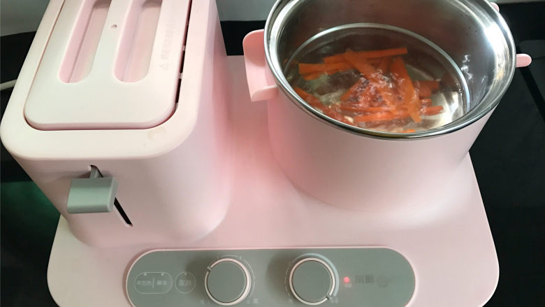 蔬菜虾仁鸡蛋饼,、锅中倒入适量水，煮开后把切成丝的胡萝卜放入锅中焯水后捞出。