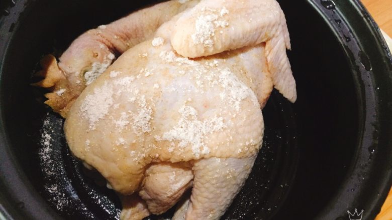 电饭煲版盐焗鸡,将鸡洗净，用厨房纸擦干或者晾干后，倒入盐焗粉1小包，边倒边涂抹均匀，腌制3个小时