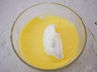 酸奶舒芙蕾蛋糕,取三分之一蛋白霜到蛋黄糊中拌匀